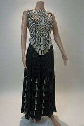 Mannequin wearing a black dress with intricate white embroidery on a light background
