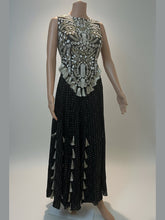 Mannequin wearing a black dress with intricate white embroidery on a light background