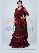 A woman modeling a deep maroon traditional Indian outfit with matching embroidered sleeves and a tiered skirt, set against a light gray background with a large 'Purvx India' watermark.