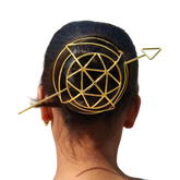 Gold geometric hair clip on a person's head against a white background
