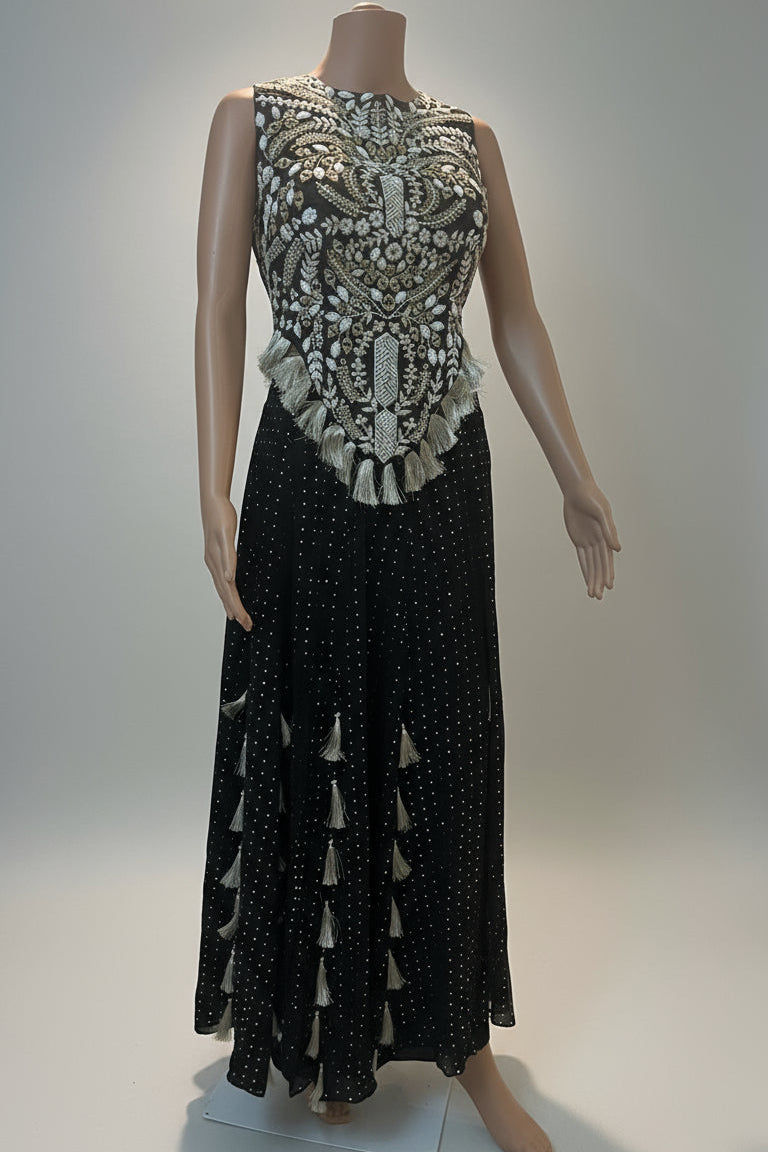Mannequin wearing a black dress with intricate white embroidery on a light background