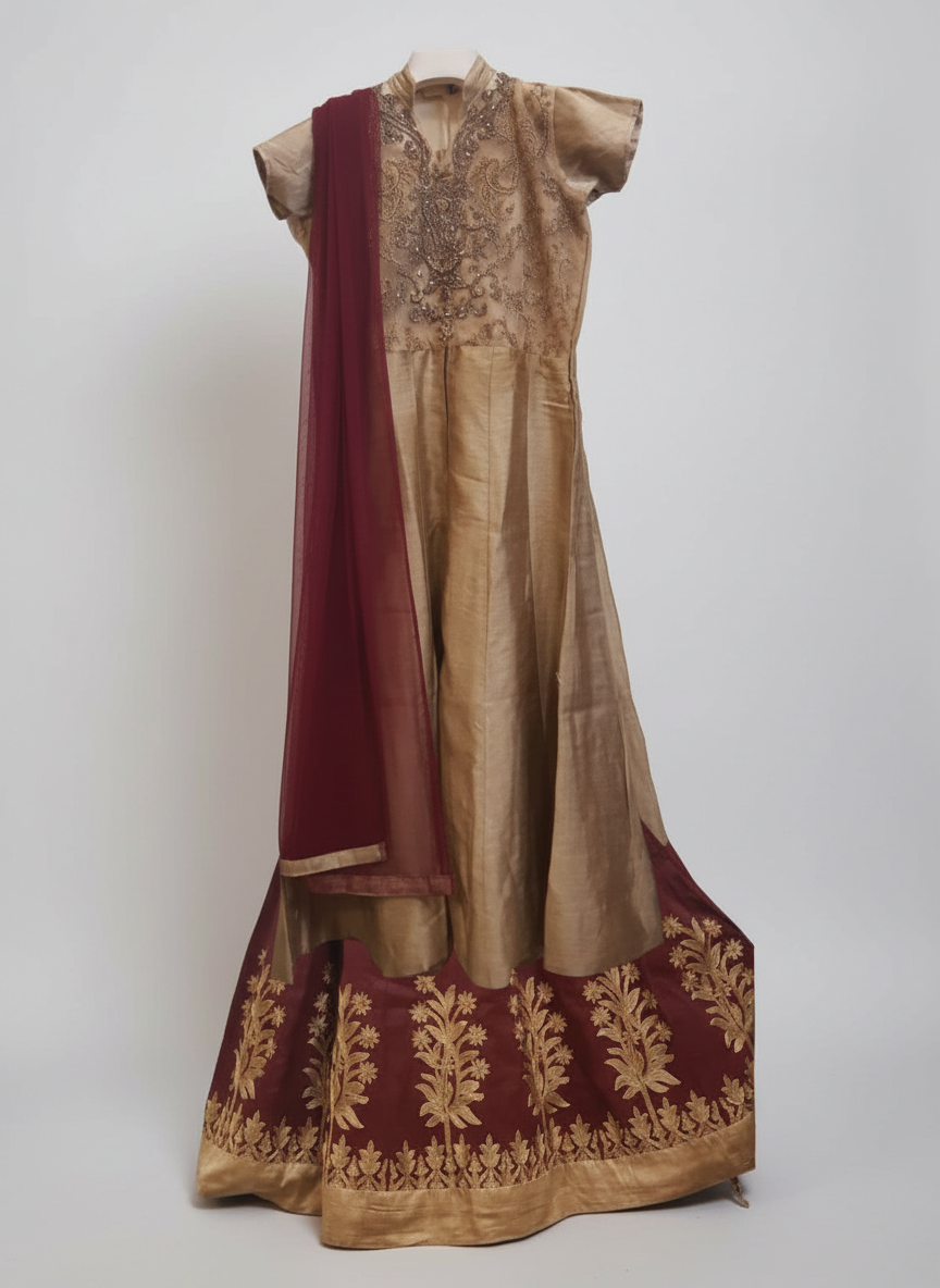 Traditional outfit with embroidered gold and maroon fabric on a white background