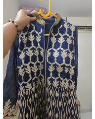 Navy blue embroidered jacket with gold patterns on a hanger.