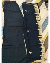 Navy blue dupatta with gold embroidery and navy blue pants on a colorful fabric background