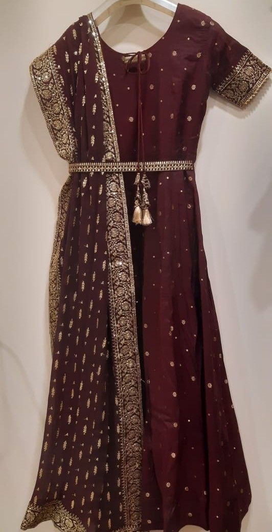 Brown dress with gold embroidery on a plain background