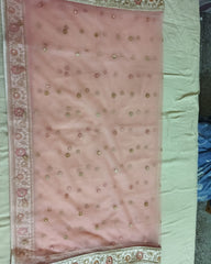 A light pink dupatta with scattered small gold and silver embellishments, laid flat on a white fabric surface.