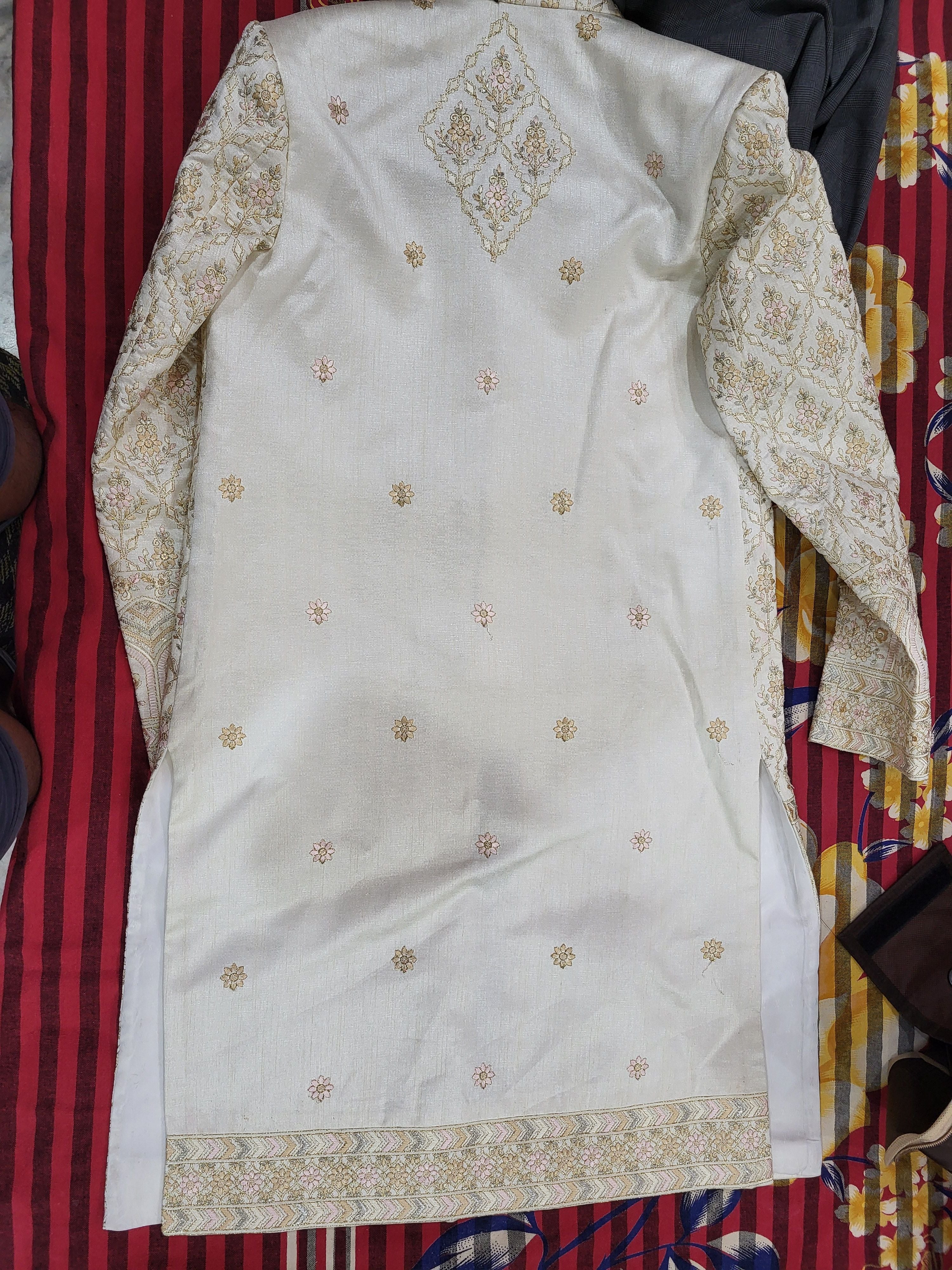 White embroidered garment on a colorful fabric background