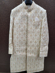 Traditional embroidered sherwani on a hanger against a dark background