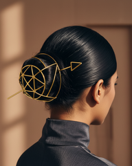 Woman with intricately styled hair featuring a gold geometric accessory against a warm-toned background
