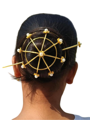 Gold hair accessory with pearls on a person's head against a white background