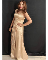Woman wearing a beige evening gown against a black background