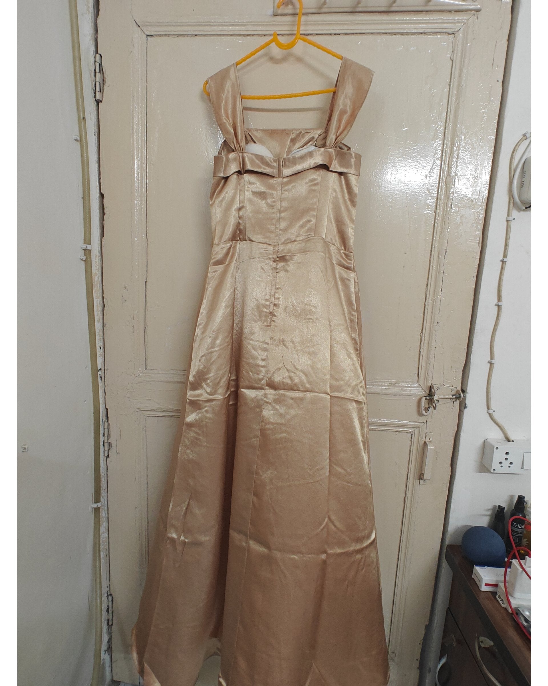 Beige evening gown hanging on a door, back view
