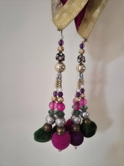 Pair of beaded latkans with colorful beads on a plain background
