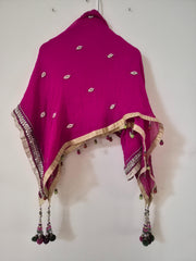 pink dupatta with gold and white patterns hanging on a white wall