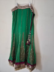 Green traditional lehenga with gold embroidery on a white background