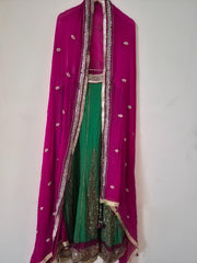 Traditional Indian outfit with pink and green colors on a white background