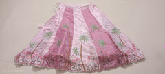 Pink lehenga skirt with floral patterns on a plain background