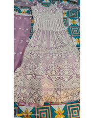 A lavender and off-white heavily embroidered sleeveless dress or anarkali-style gown laid flat, with a matching sheer embroidered dupatta partially visible on the left. The garment features intricate floral and geometric lace patterns across the bodice and full skirt.