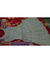 A light purple/lavender embroidered dress or kurta laid flat on a red floral fabric background.