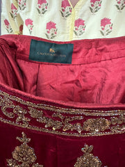 Close-up of a maroon fabric with gold embroidery and a visible brand label, Calcutta Regalia