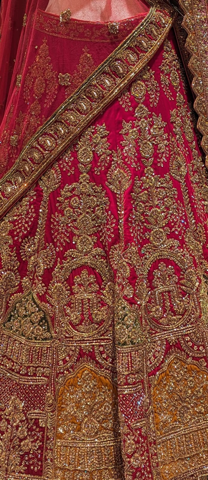 Close-up of a red lehenga with intricate gold embroidery