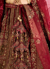 Close-up of a red and gold embroidered bridal lehenga skirt with intricate patterns.