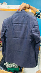 Blue blazer on a hanger against a blue background
