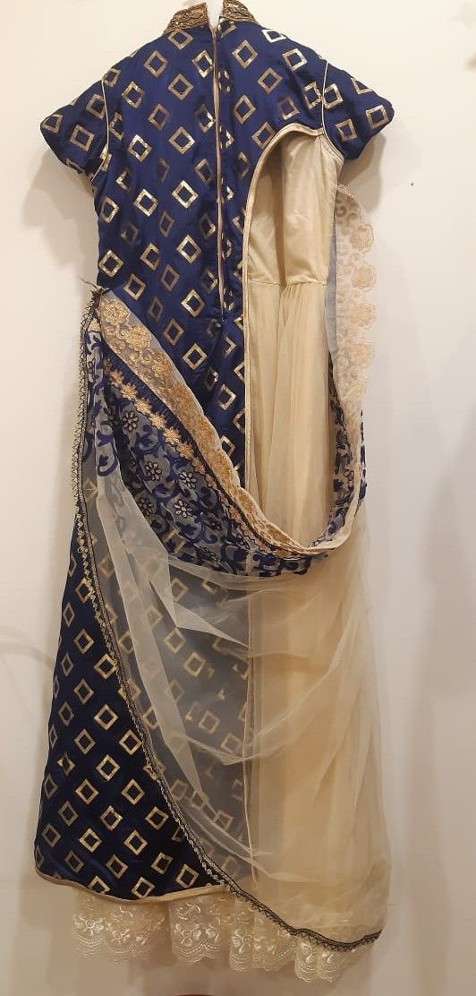 Traditional blue and gold embroidered garment on a white background