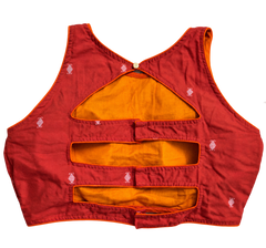 An orange sleeveless cotton Jamdani blouse with multiple horizontal cutouts and a small gold button at the back neckline, featuring small white embroidered motifs, shown against a plain white background.