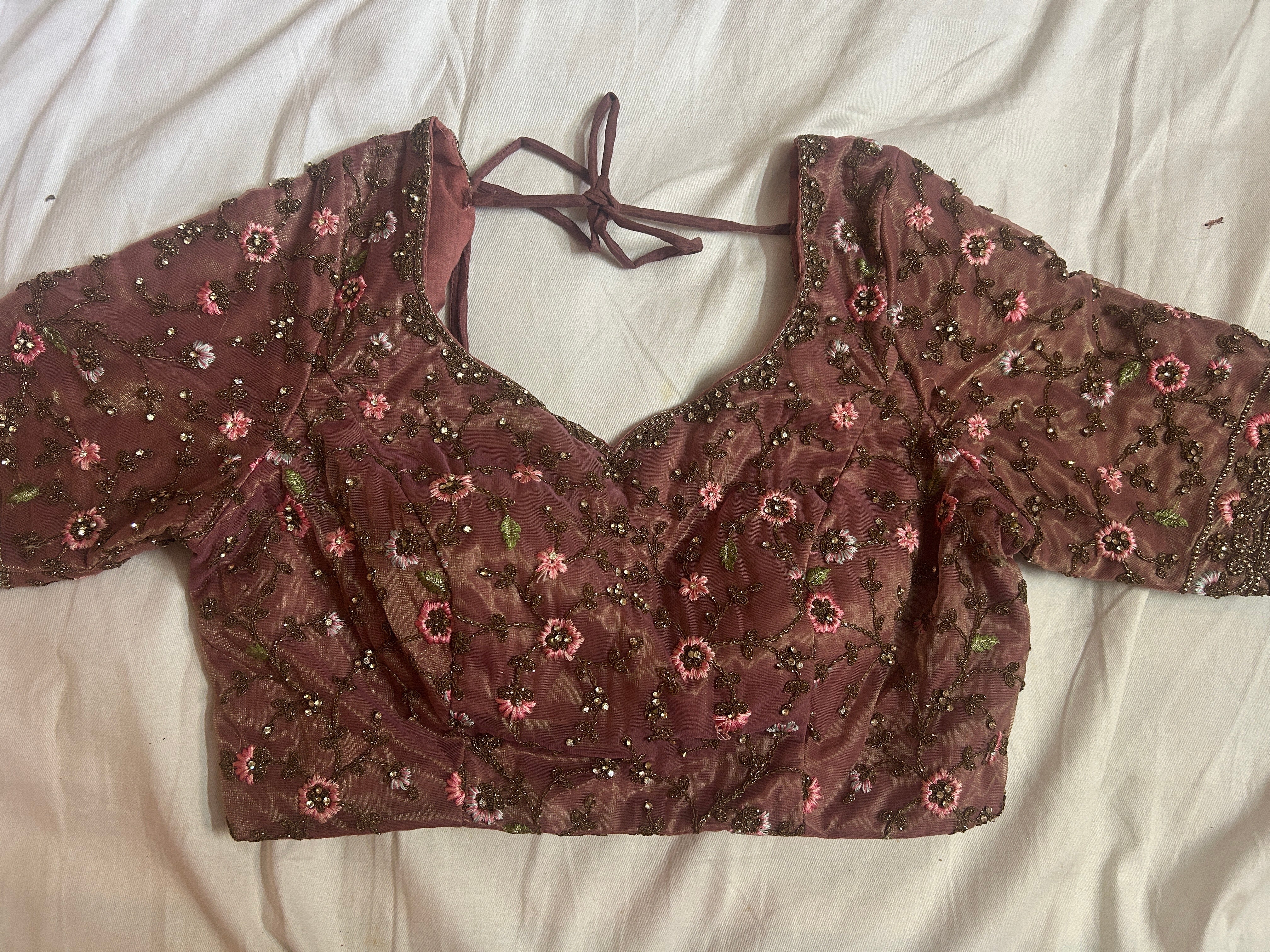 Brown floral choli top on a white fabric background