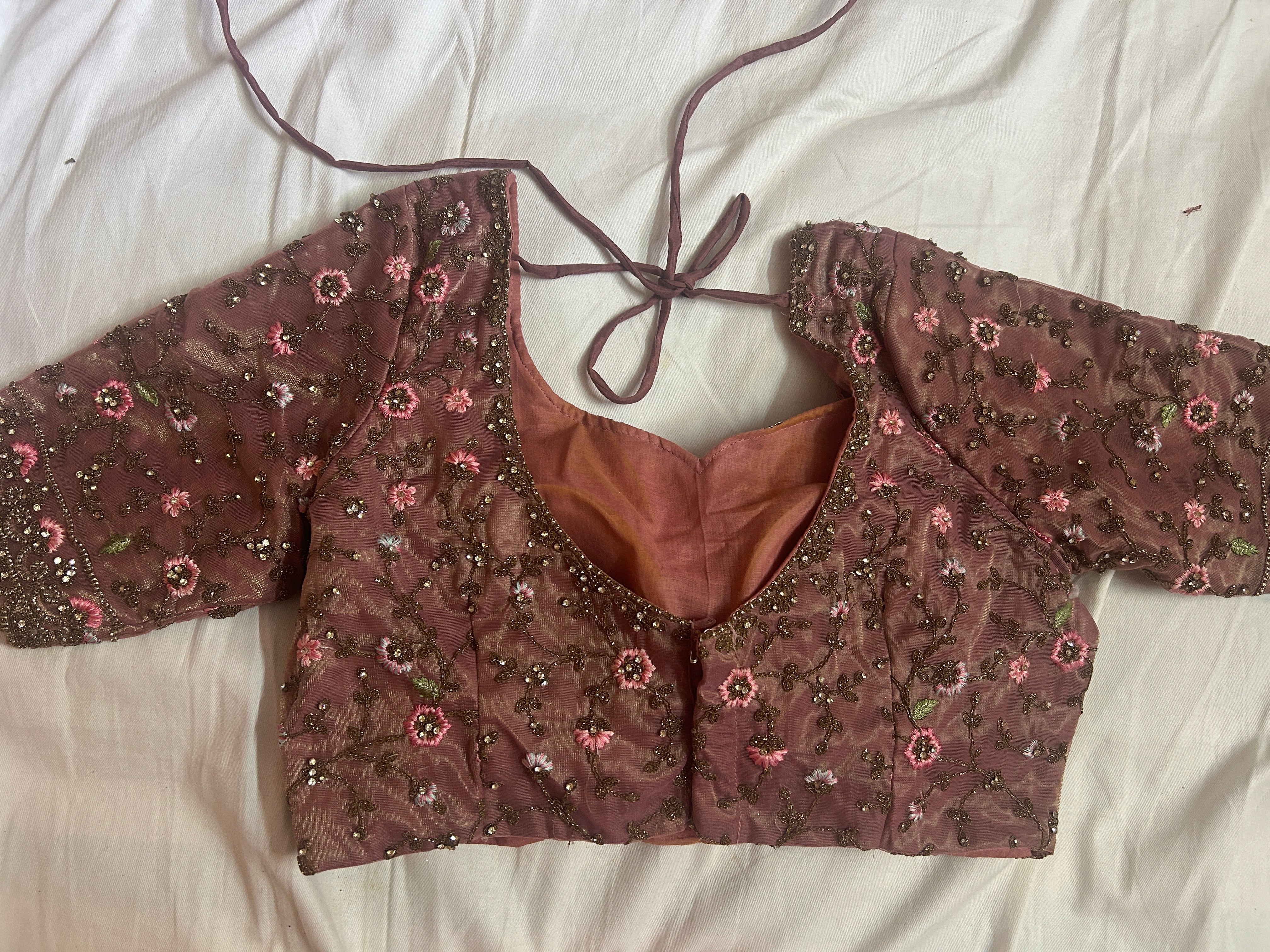 back view of Brown embroidered blouse on a white fabric background