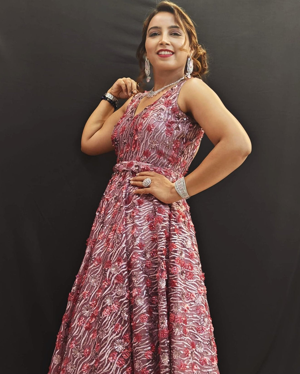 Woman wearing a patterned dress against a black background