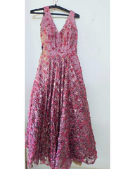Pink floral dress on a hanger against a white background