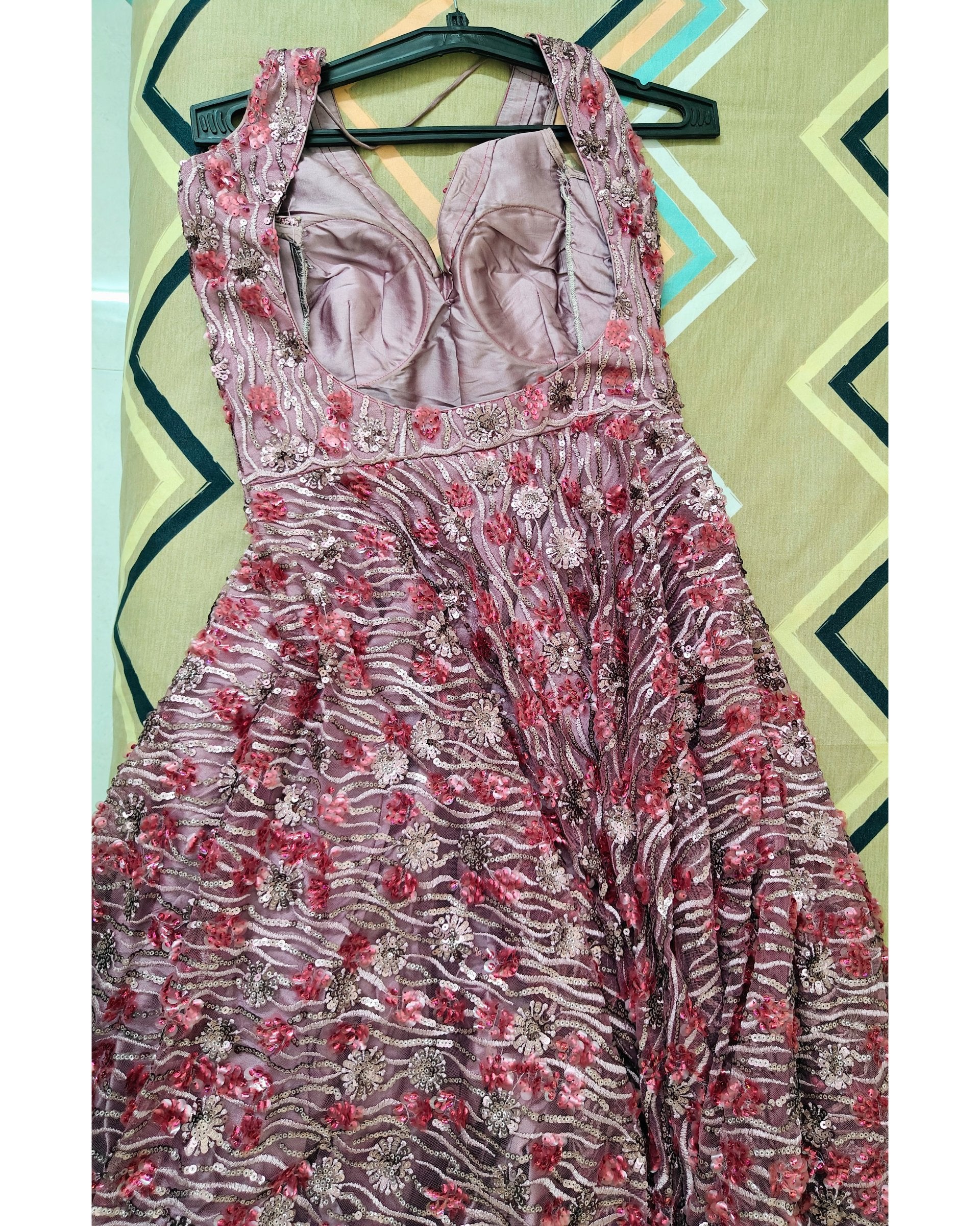 Floral dress on a hanger against a geometric patterned wall