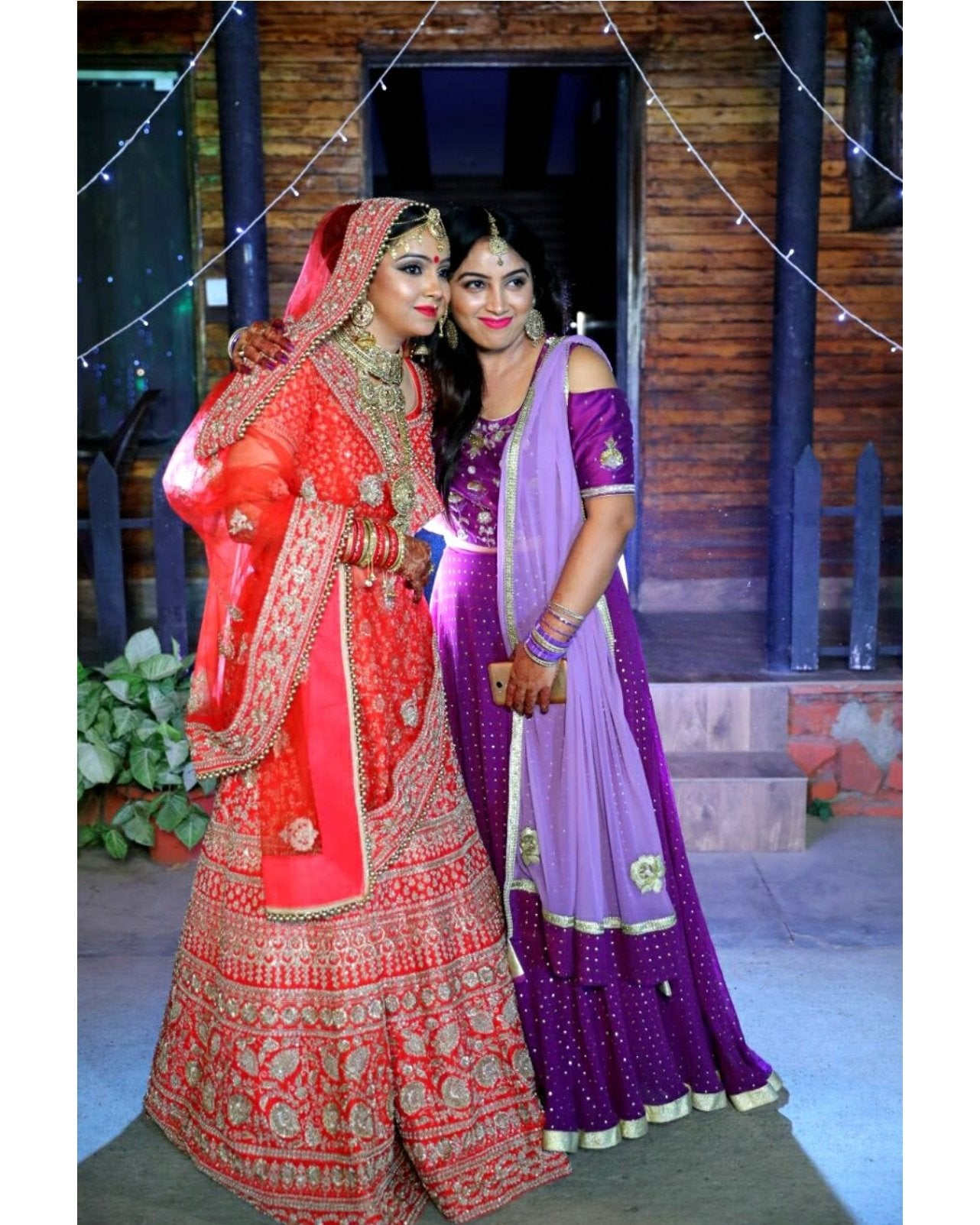 Two women in traditional Indian attire standing together outdoors.