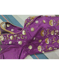 Purple blouse with gold embroidery on a striped fabric background