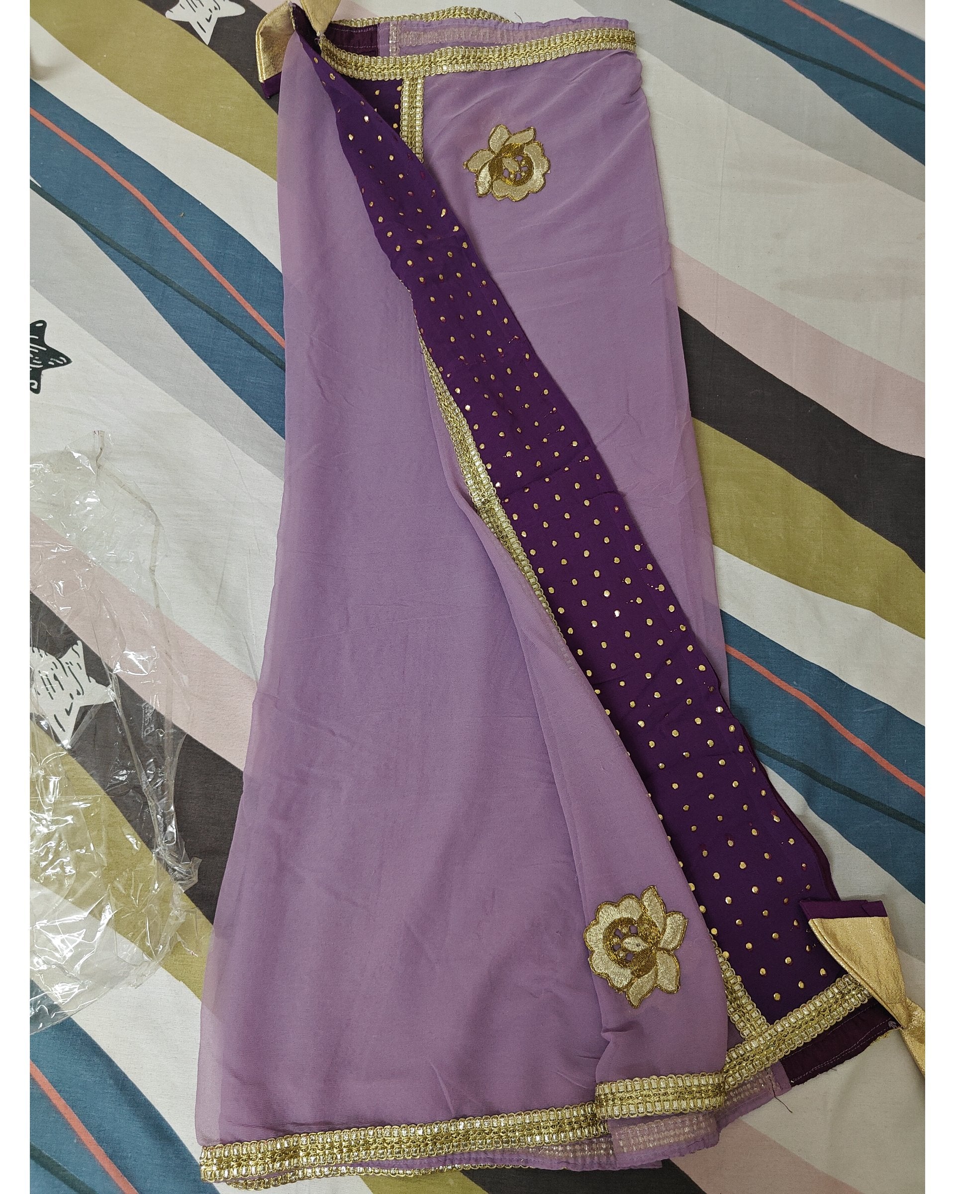 Purple dupatta with gold border and floral embellishments on a striped background