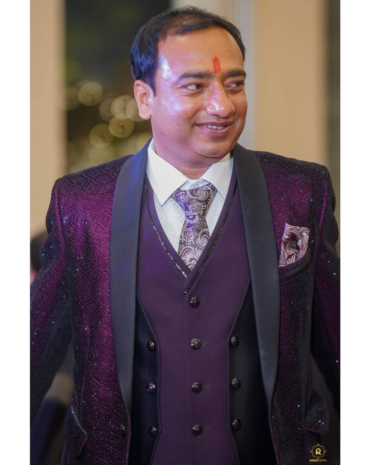 A man wearing a dark purple three-piece suit with a sparkling purple jacket, a matching pleated vest, and a patterned tie, shown in a mobile app screenshot.