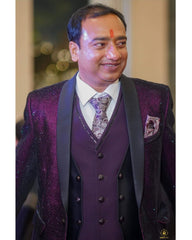 A man wearing a dark purple three-piece suit with a sparkling purple jacket, a matching pleated vest, and a patterned tie, shown in a mobile app screenshot.