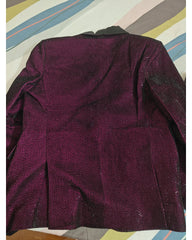 A dark plum purple textured fabric garment, back view of jacket, laid flat on a striped background.