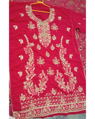 Red embroidered garment on a hanger with a floral pattern