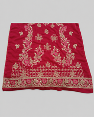 Red fabric with gold and pink embroidery on a gray background