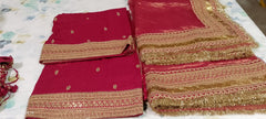 Red dupatta with gold embroidery on a light floral bedsheet
