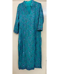 Teal kurta with purple floral pattern hanging on a white door.