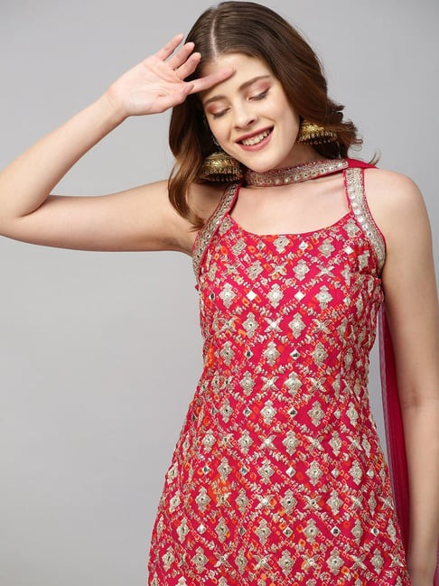 Woman wearing a red and gold embroidered traditional outfit on a gray background