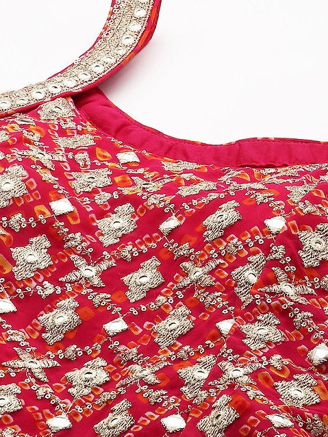Close-up of a red garment with intricate gold and silver embroidery on a white background