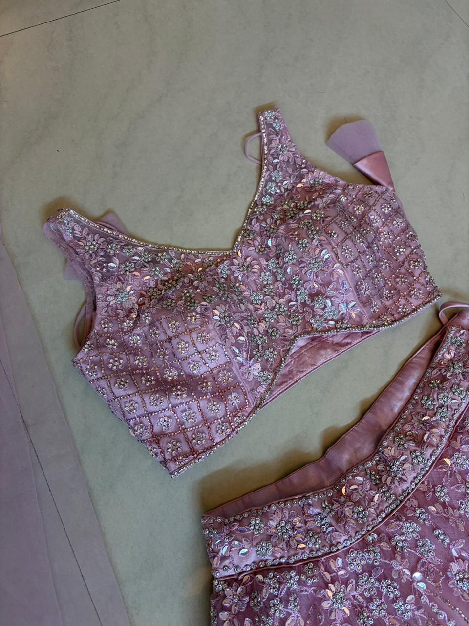 Pink embroidered lehenga choli on a light surface