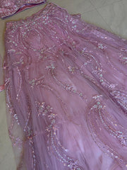 Pink embroidered lehenga with floral patterns on a tiled floor