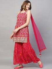 Woman wearing a traditional outfit with a pink dupatta on a gray background