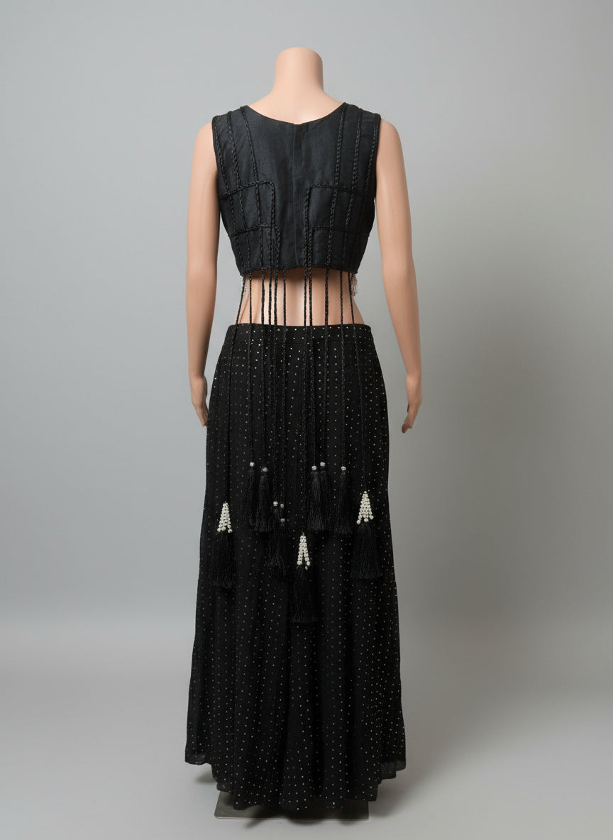 Black sleeveless top and long black skirt with bead details on a white background